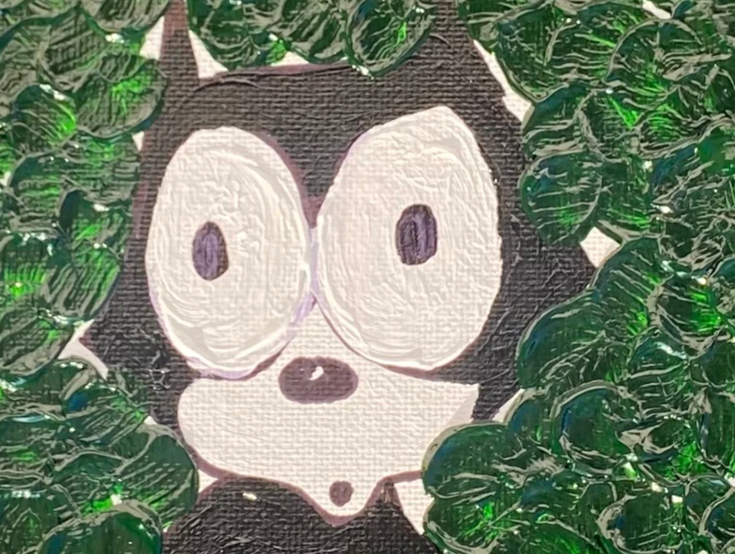 Cartoon character with large eyes surrounded by green leaves