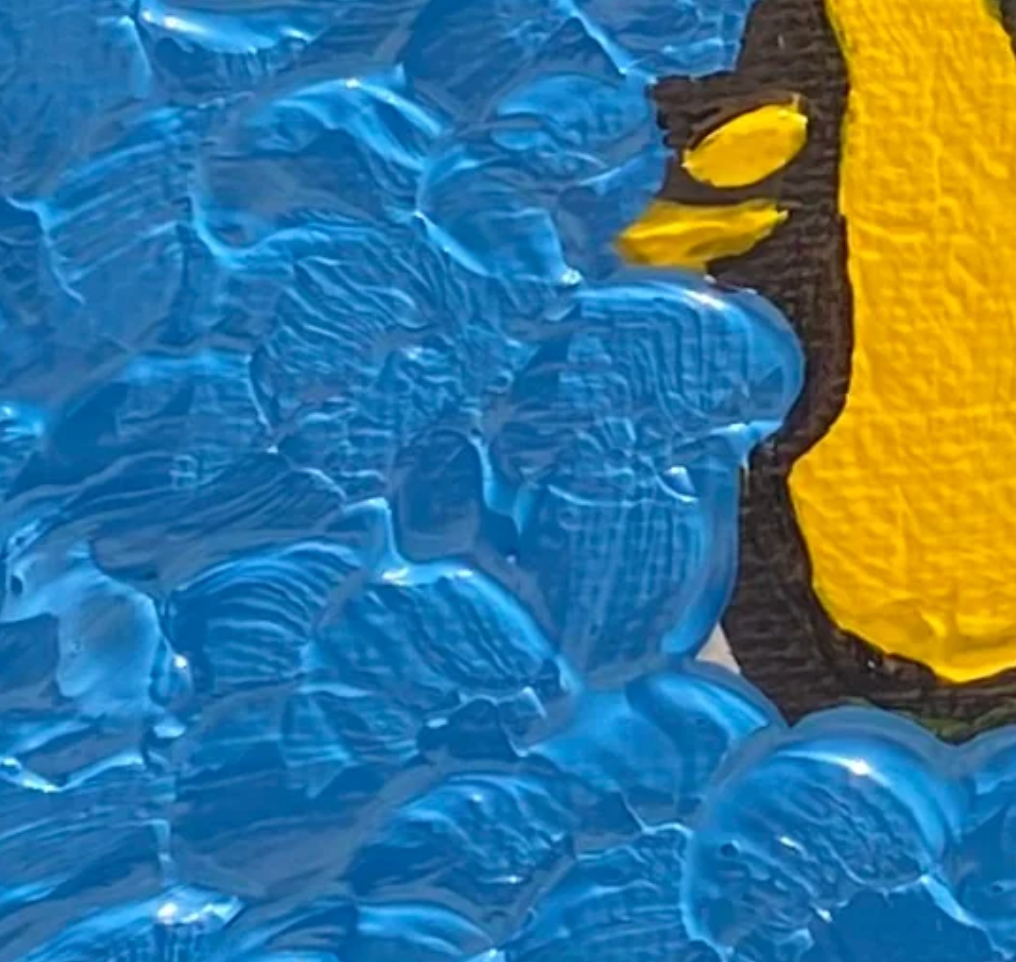 Close-up of blue textured surface with yellow object partially visible